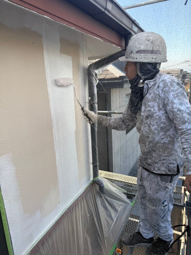 ローラーで外壁を均一に塗り広げる作業