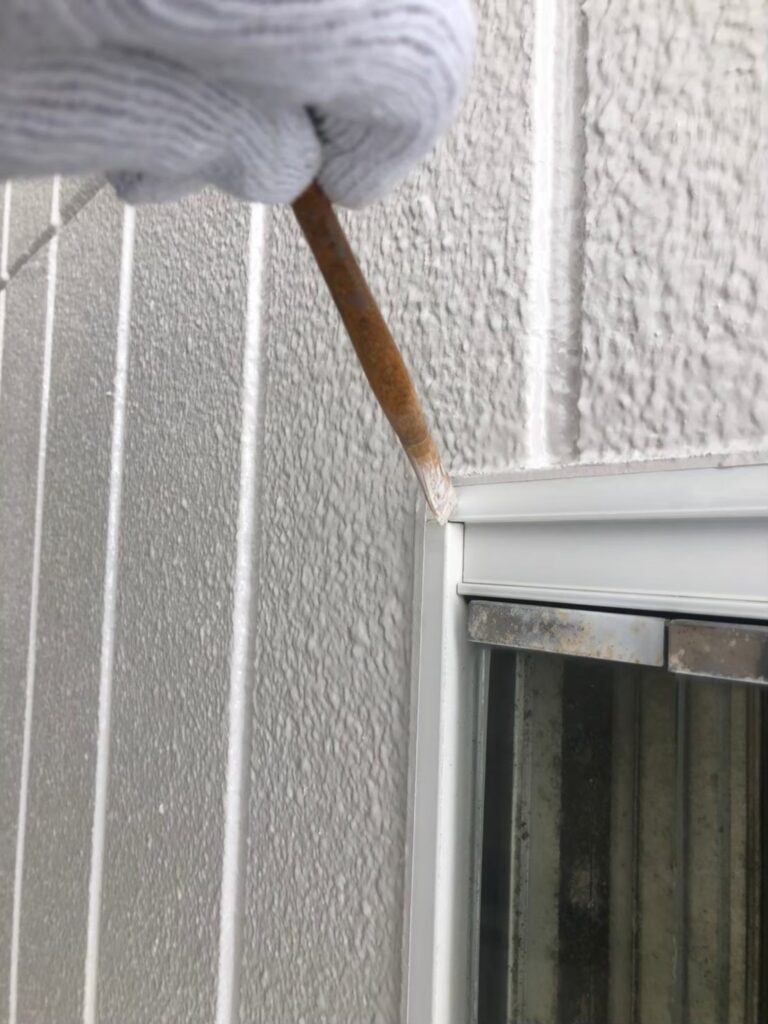 ローラーで外壁を塗装する作業